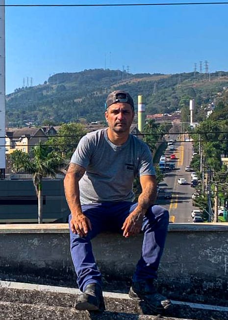 Davi Borges sentado ao entardecer com Porto Alegre ao fundo